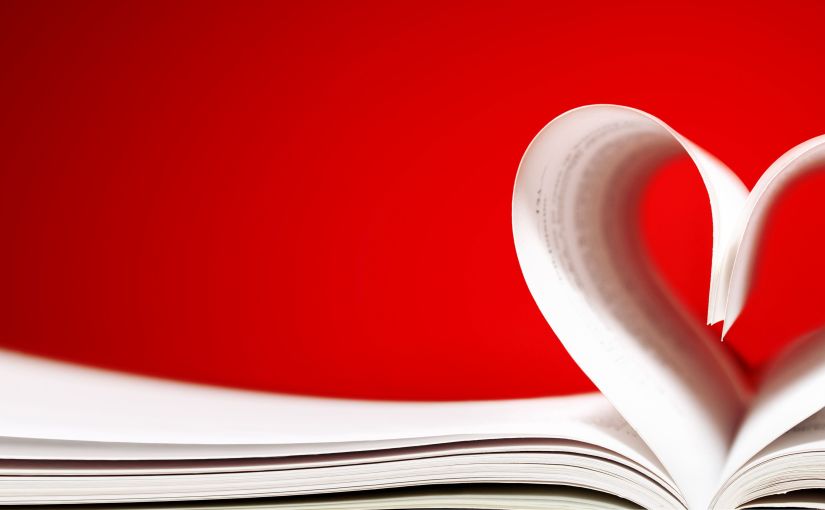 Ein aufgeschlagenes Buch, in dem zwei Seiten zu einem Herz zusammengerollt sind